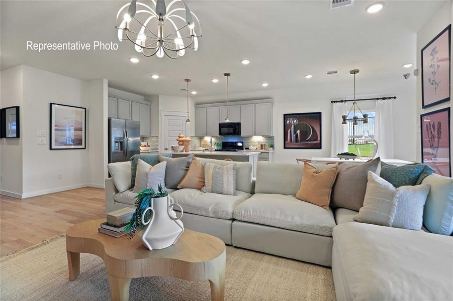 Spacious interior featuring wood-finish flooring, recessed lighting, a contemporary chandelier, light-toned cabinetry, and stainless steel appliances Spacious interior featuring wood-finish flooring, recessed lighting, a contemporary chandelier, light-toned cabinetry, and stainless steel appliances