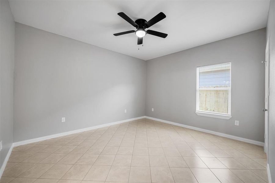 Spare room featuring ceiling fan and light tile patterned floors