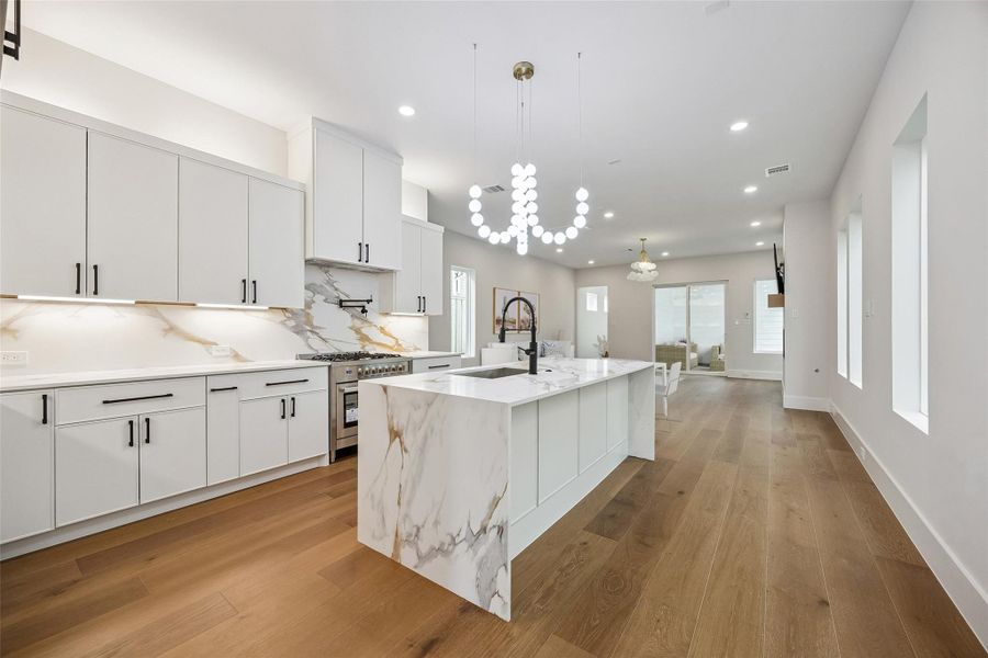 The waterfall quartz island creates a strong visual centerpiece while still leaving generous circulation throughout the kitchen. Custom cabinetry and integrated storage help the space feel functional without sacrificing design. The waterfall quartz island creates a strong visual centerpiece while still leaving generous circulation throughout the kitchen. Custom cabinetry and integrated storage help the space feel functional without sacrificing design.