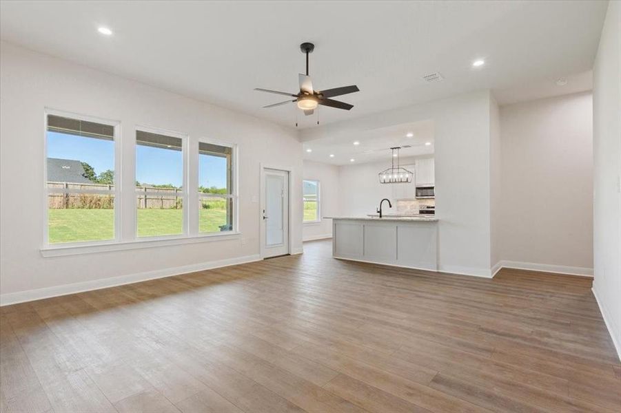 Unfurnished living room with recessed lighting, light wood-type flooring, and a ceiling fan Unfurnished living room with recessed lighting, light wood-type flooring, and a ceiling fan