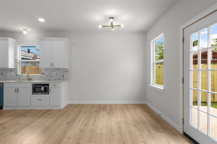 Open-concept area featuring light wood-finish flooring and white walls