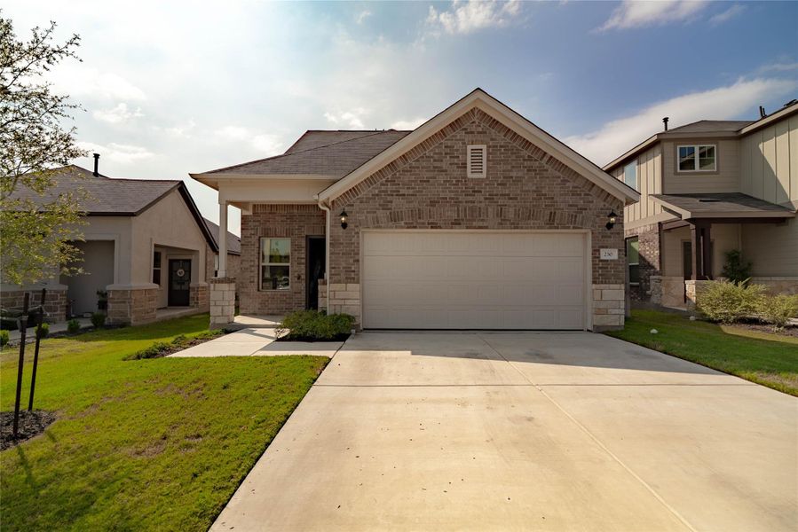 View of front of home with a garage, brick siding, driveway, and a front yard View of front of home with a garage, brick siding, driveway, and a front yard