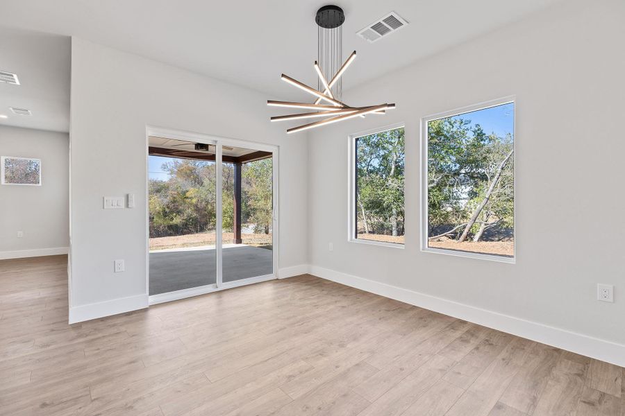 Unfurnished dining area with a chandelier, plenty of natural light, and light wood finished floors