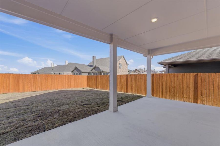 Fenced backyard featuring a patio and a residential view