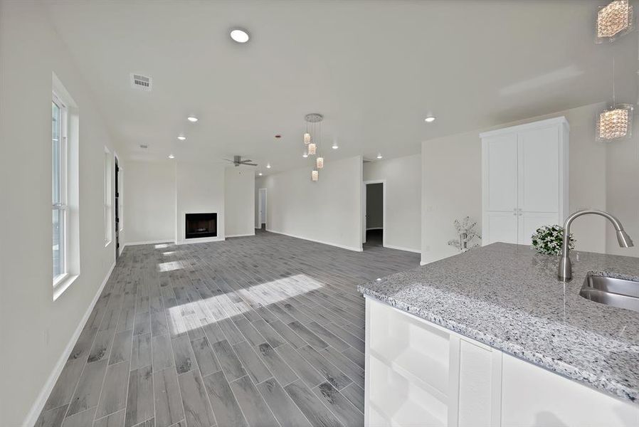 Unfurnished living room with light wood finished floors, recessed lighting, ceiling fan, and a fireplace