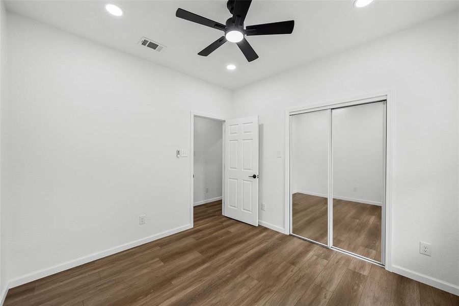 Bedroom featuring wood-finish flooring, a contemporary ceiling fan with integrated lighting, and recessed ceiling lights Bedroom featuring wood-finish flooring, a contemporary ceiling fan with integrated lighting, and recessed ceiling lights