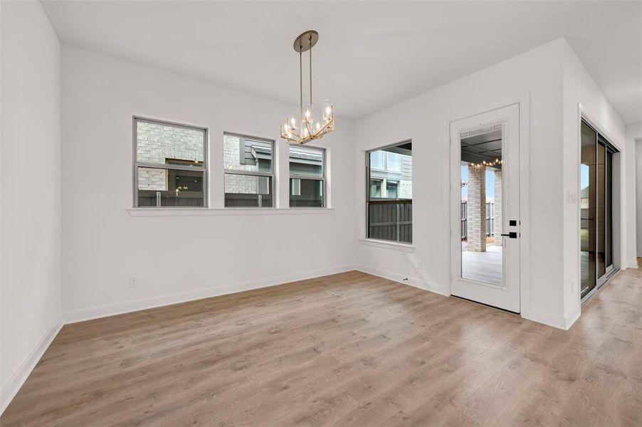 Unfurnished dining area featuring suspended lighting and light wood finished floors