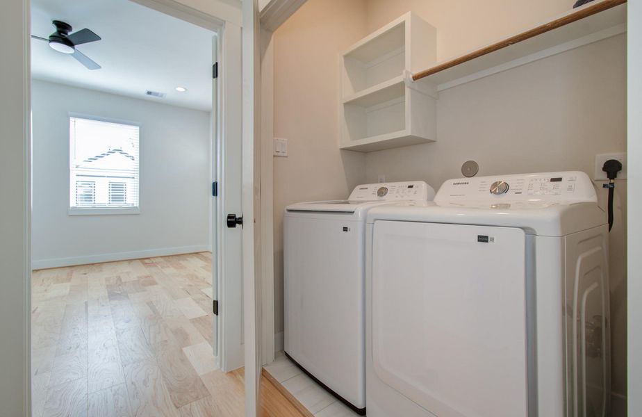 Even chores feel elevated in your new home. This utility space offers everything you need—ample room for full-size appliances, upper shelving for organization, and a clean, modern aesthetic.