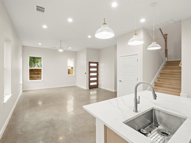 Open-concept living space featuring polished concrete flooring, recessed lighting, and a contemporary ceiling fan