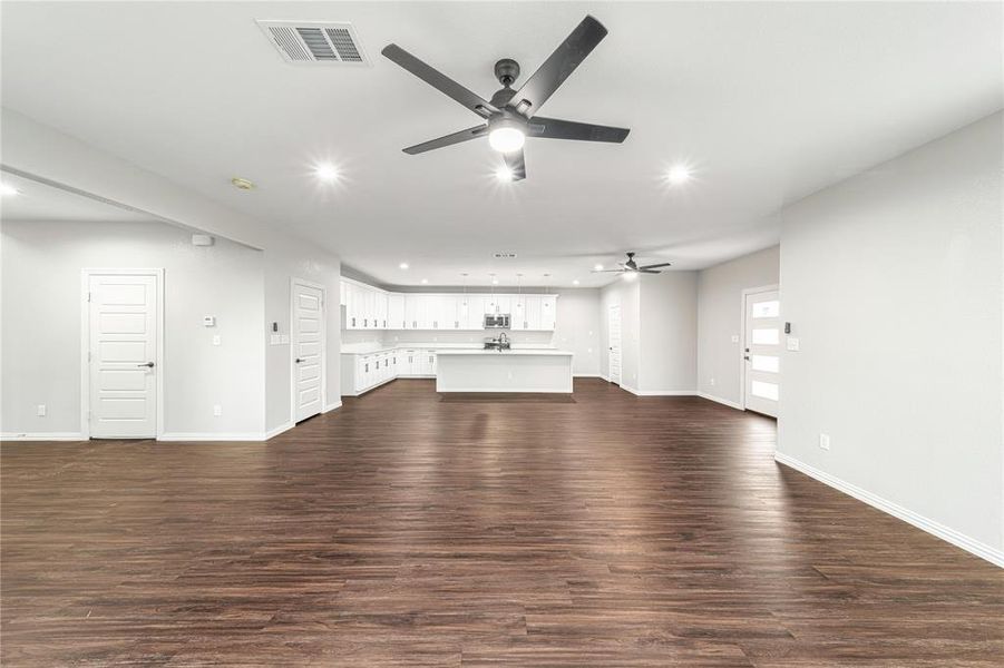 Unfurnished living room featuring dark wood-type flooring, recessed lighting, and ceiling fan