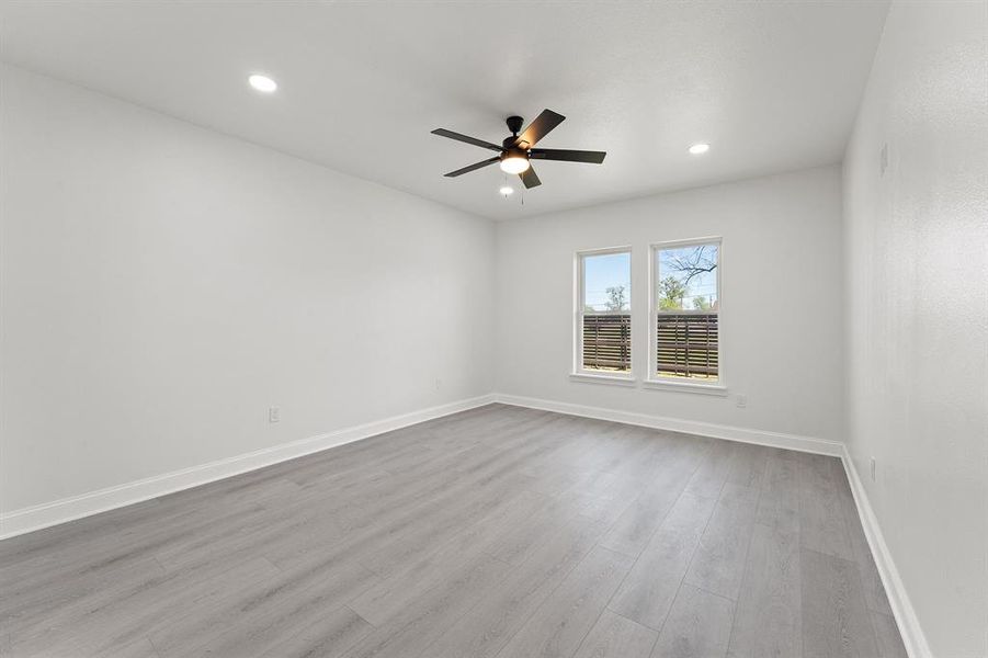 Spare room featuring light wood finished floors, ceiling fan, and recessed lighting
