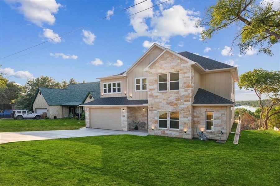 View of front facade featuring a garage and a front lawn