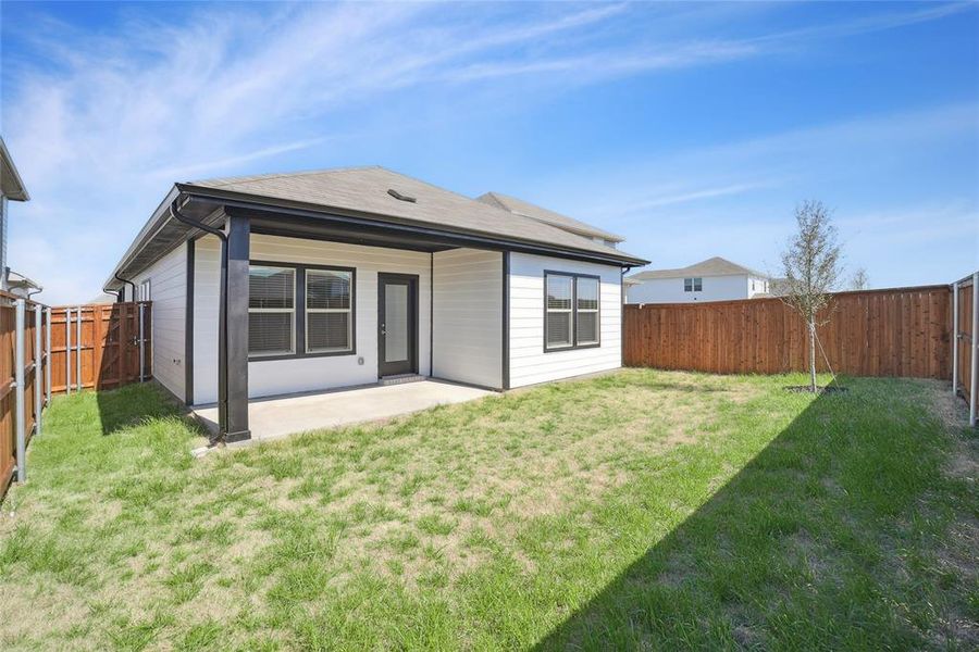 Rear view of house featuring a patio area and a fenced backyard