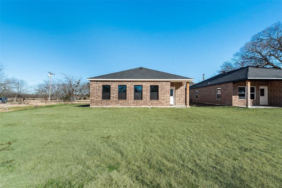 Back of house featuring a yard