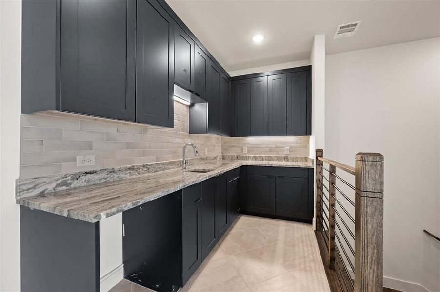 A wet bar located just off the game room creates an additional entertainment area.