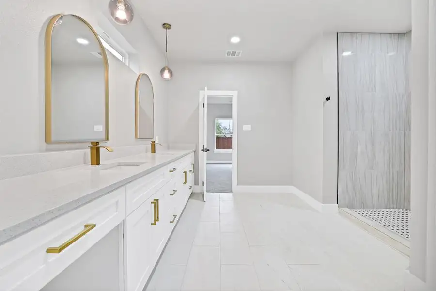 Bathroom featuring vanity and tiled shower