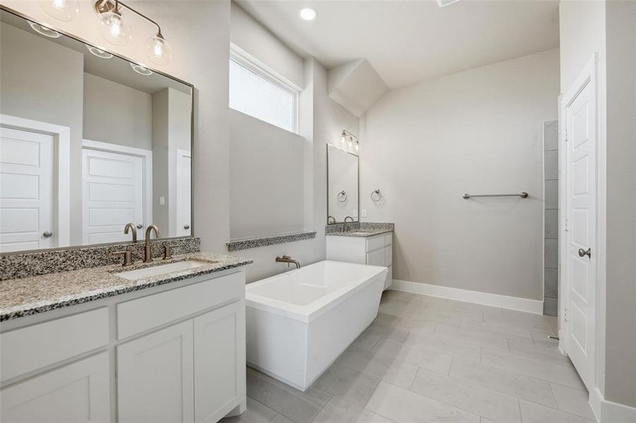 Bathroom featuring a freestanding bath and two vanities
