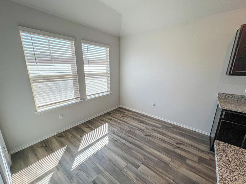 Unfurnished dining area with dark wood finished floors and baseboards