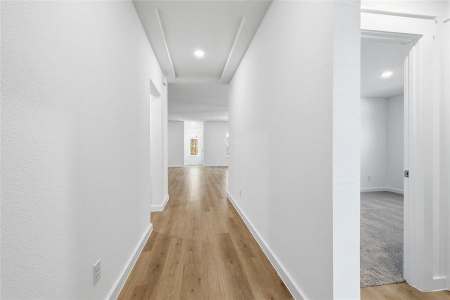 Hall with light wood-style flooring and recessed lighting