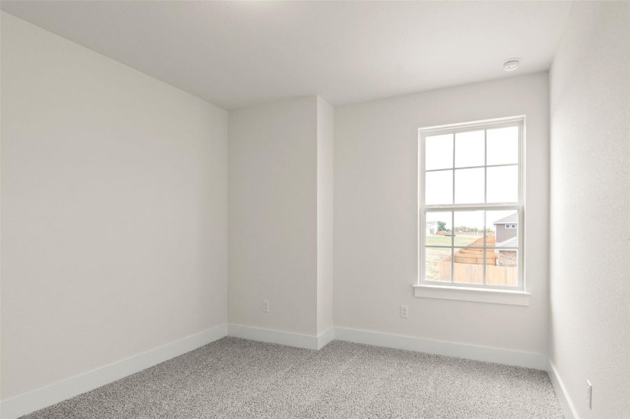 Spare room with baseboards and light carpet