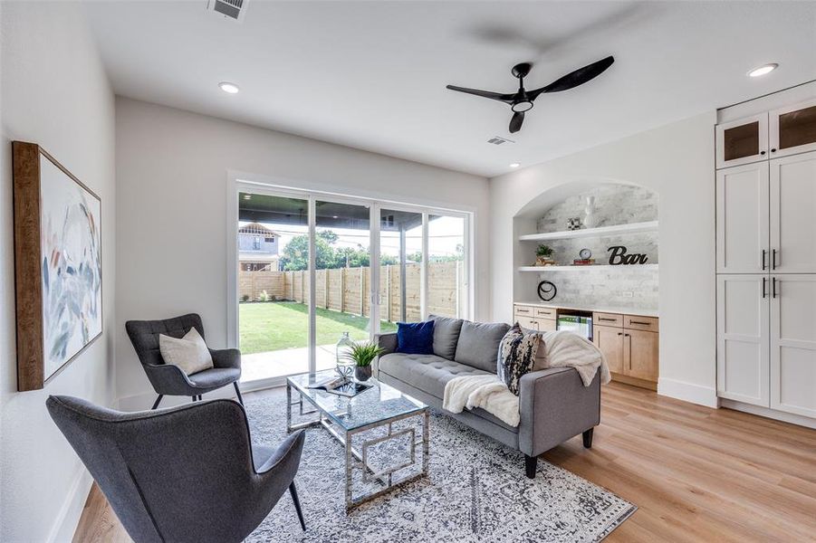 Living area featuring a bar, wine cooler, a ceiling fan, light wood finished floors, and recessed lighting Living area featuring a bar, wine cooler, a ceiling fan, light wood finished floors, and recessed lighting