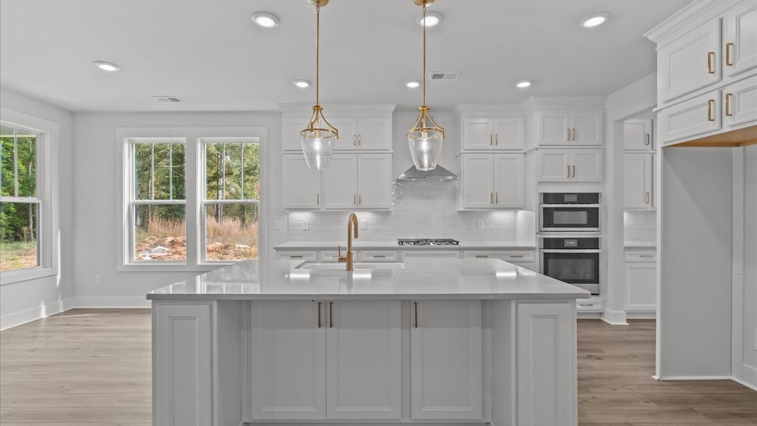 Highly skilled craftsmanship shines in this modern kitchen with pendant lighting and a central island focal point