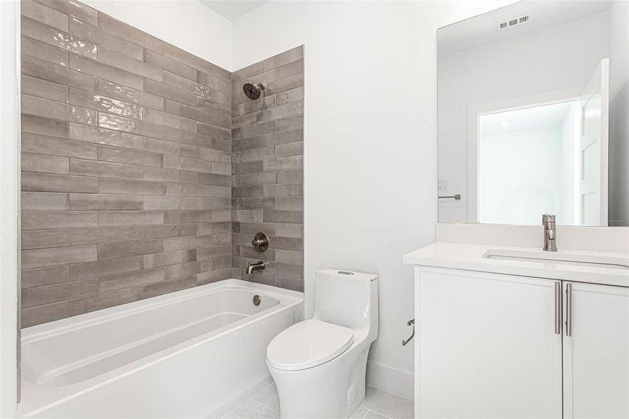Bathroom featuring washtub / shower combination, vanity, and toilet