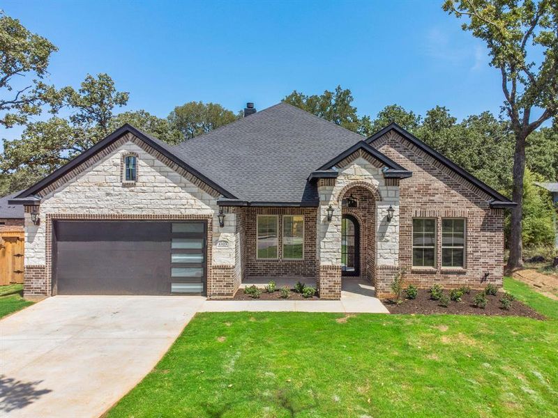 View of front of home with a garage and a front lawn