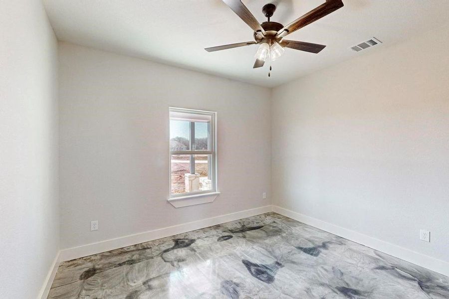 Empty room featuring a ceiling fan, visible vents, and baseboards