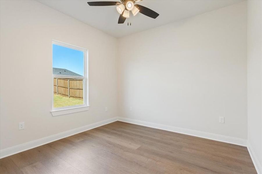 Spare room featuring wood finished floors and a ceiling fan