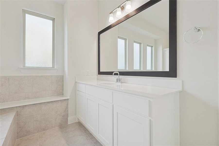 Bathroom with vanity, a healthy amount of sunlight, and tile patterned floors