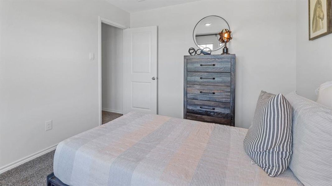 Bedroom featuring carpet and baseboards