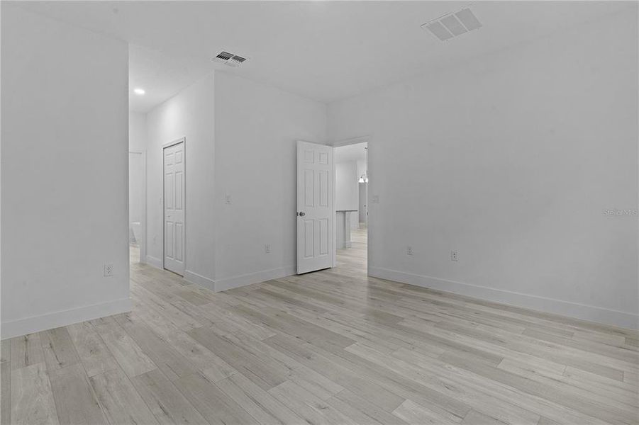 Primary bedroom looking toward the door, on the left is his/hers walk-in closets and then the primary bathroom