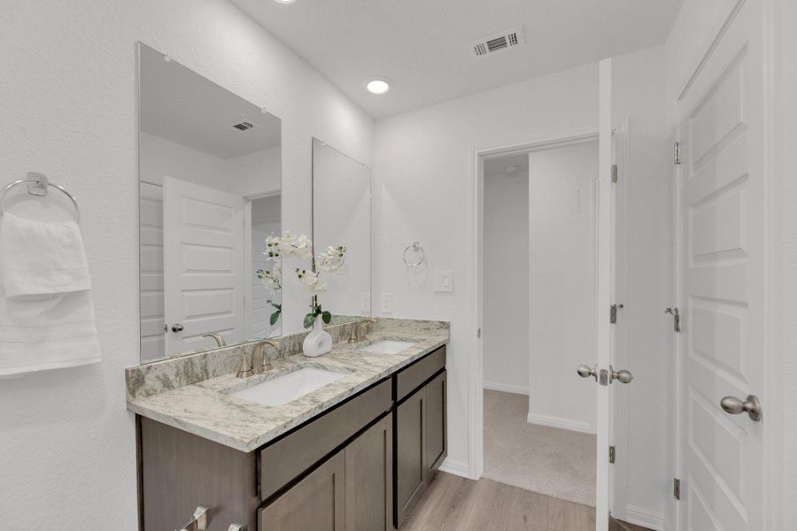 Bathroom featuring light wood finished floors, double vanity, and recessed lighting Bathroom featuring light wood finished floors, double vanity, and recessed lighting