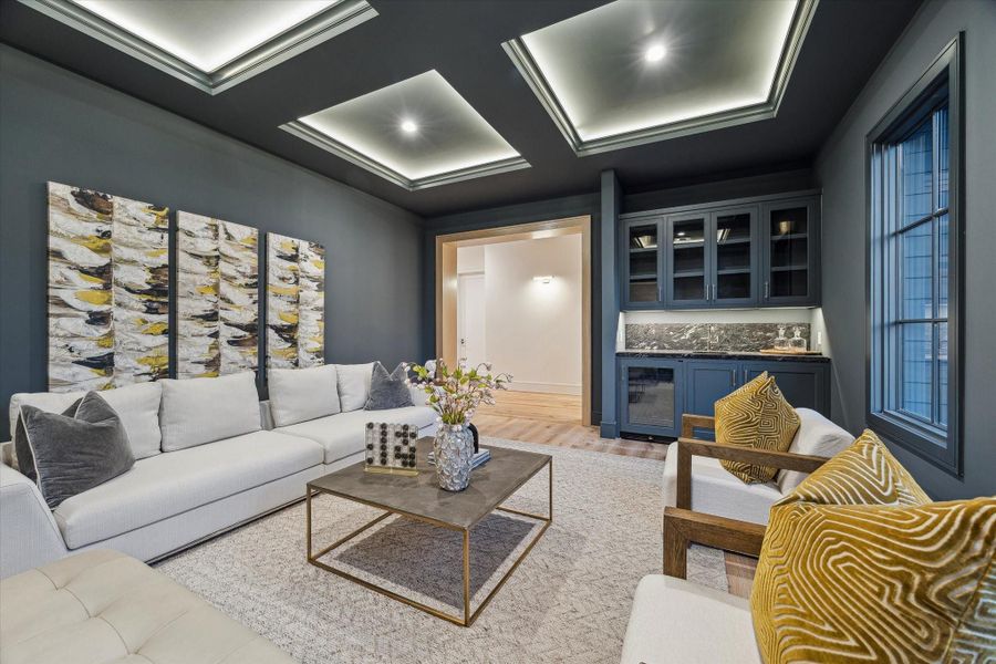 The magnificent media room is adorned with a quartet of tray cutouts with dramatic lighting for a regal, unique appearance. The wet bar is accented with black leathered quartzite countertops and glass-fronted cabinets, and sink and beverage chiller are great for sodas and wine!