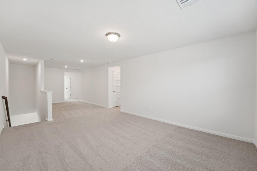 Unfurnished room with light colored carpet and recessed lighting