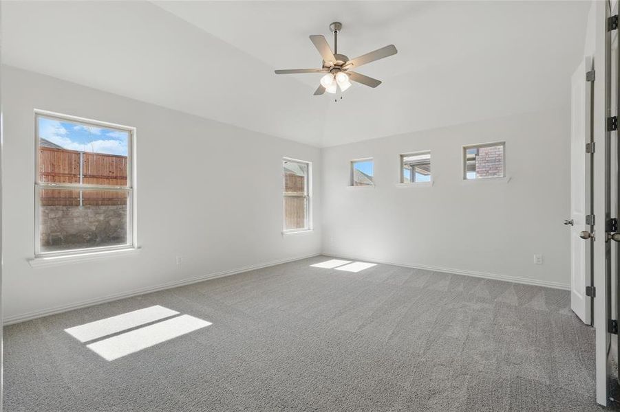 Carpeted spare room featuring baseboards and a ceiling fan