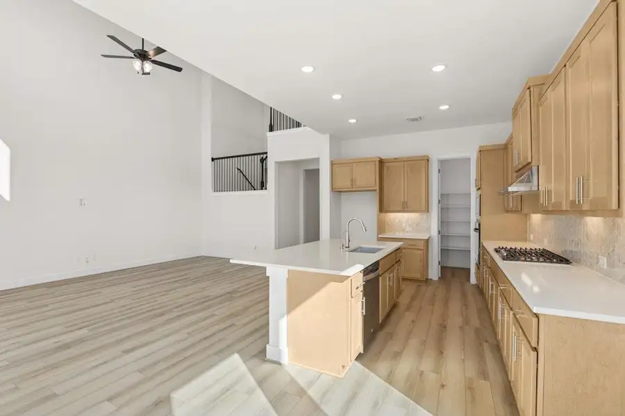 Kitchen featuring decorative backsplash, a kitchen island with sink, light wood-type flooring, recessed lighting, and open floor plan Kitchen featuring decorative backsplash, a kitchen island with sink, light wood-type flooring, recessed lighting, and open floor plan