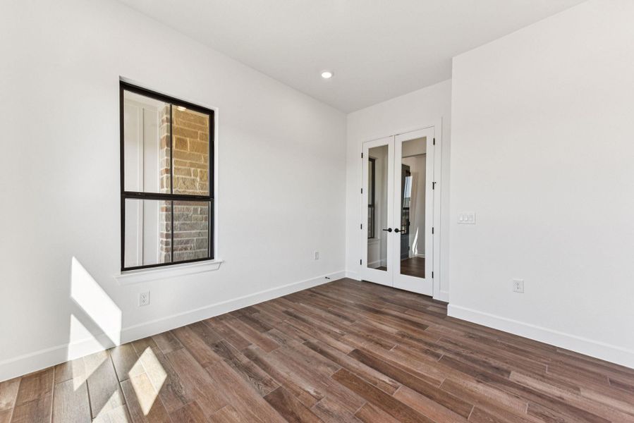 Unfurnished room featuring french doors, dark wood-style flooring, and recessed lighting