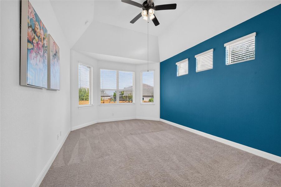 A spacious bedroom boasts soaring vaulted ceilings and soft carpeting underfoot. A spacious bedroom boasts soaring vaulted ceilings and soft carpeting underfoot.