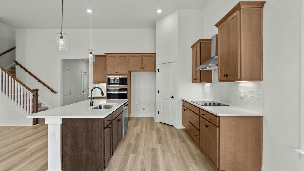 Modern kitchen with quartz counters and 42-inch cabinets at Chestnut Farms by DRB Homes