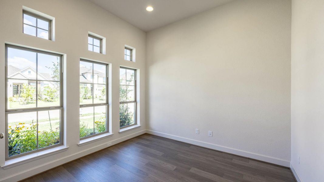 Unfurnished room featuring healthy amount of natural light, dark wood finished floors, and recessed lighting Unfurnished room featuring healthy amount of natural light, dark wood finished floors, and recessed lighting