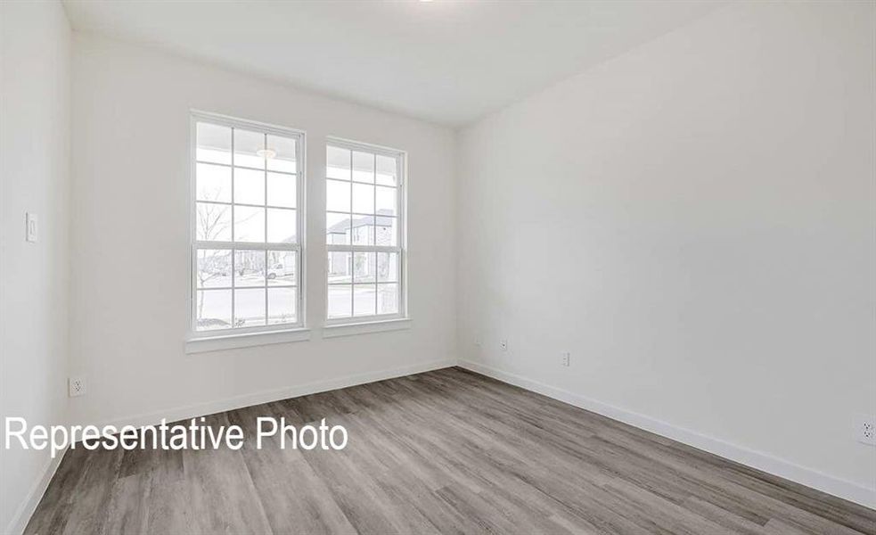 Unfurnished room with a healthy amount of sunlight and wood-type flooring