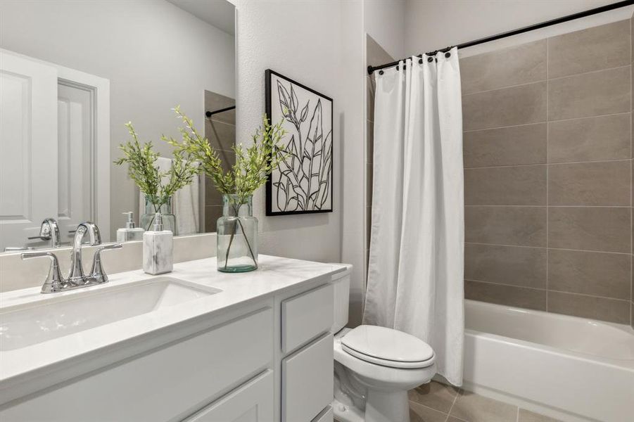 Full bathroom featuring shower / tub combo, vanity, tile patterned flooring, and toilet