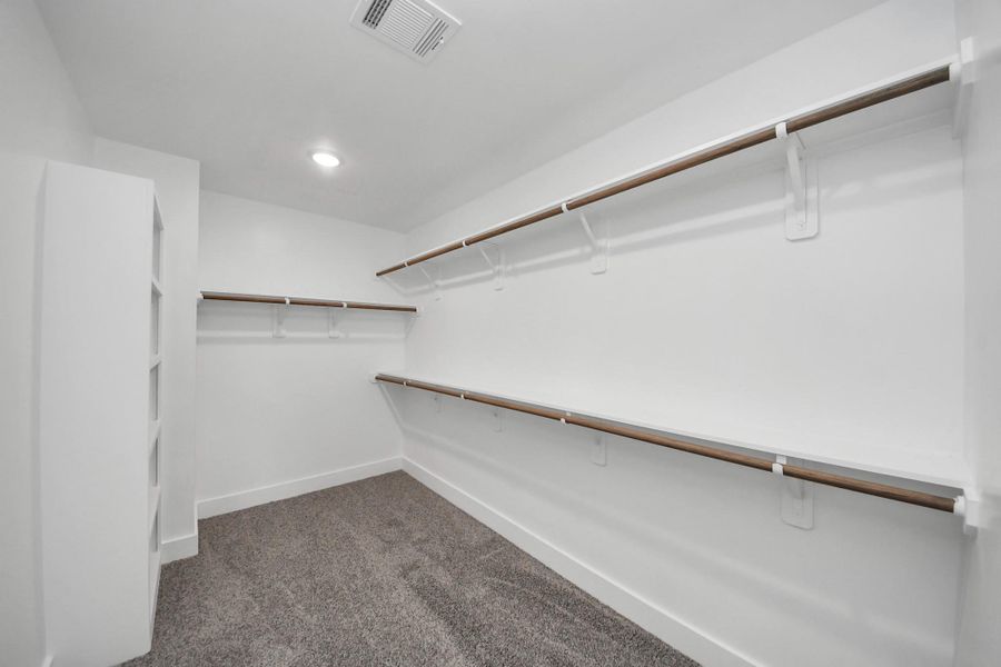 Primary Walk-In Closet – Spacious walk-in closet with built-in shelving, abundant hanging space, and organized storage.