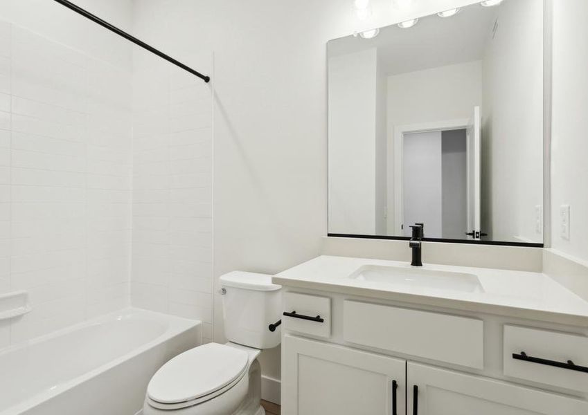 The secondary bathroom has a spacious vanity and shower-tub combo.