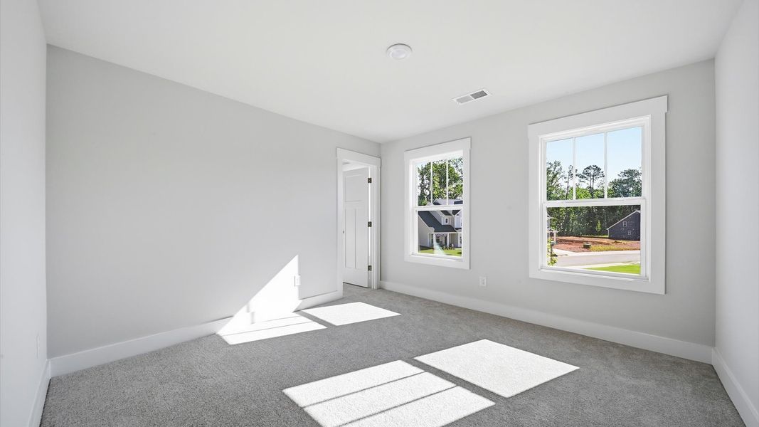 Refined bedroom design with large windows for daylight-filled mornings and peaceful views in Anderson, SC