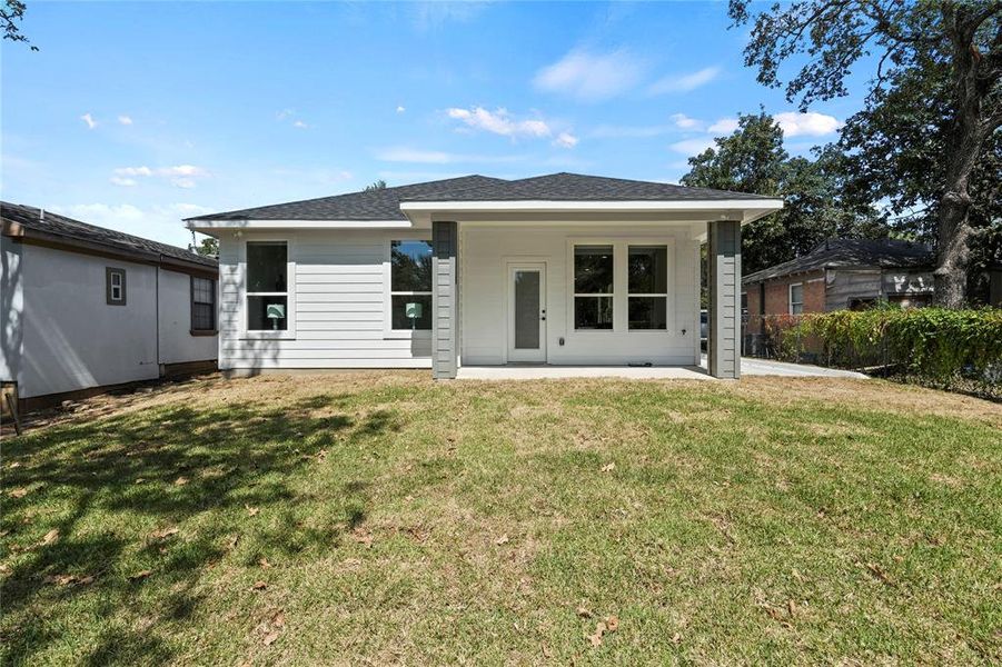 Rear view of property with a patio and a yard