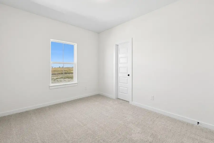 Empty room with baseboards and light carpet