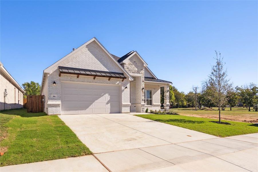 View of front of property featuring a front lawn and a garage